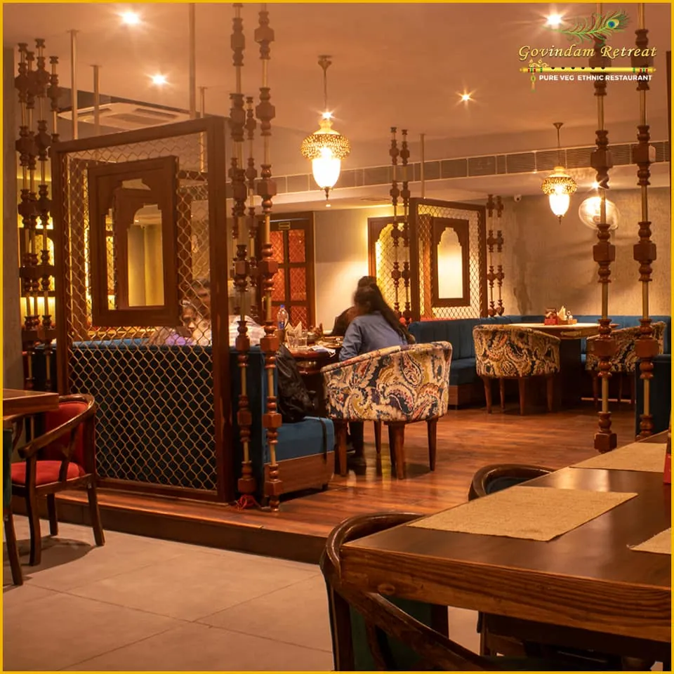 Guests dining in the warm evening light at Govindam Retreat pure veg ethnic restaurant