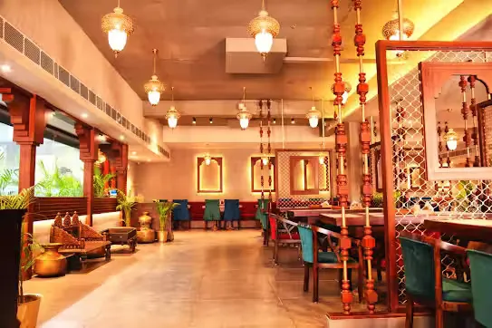 Long dining hall with brass lanterns and lattice screens at Govindam Retreat